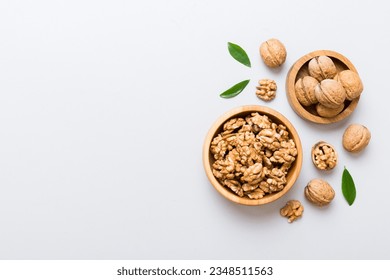 Walnut kernel halves, in a wooden bowl. Close-up, from above on colored background. Healthy eating Walnut concept. Super foods with copy space.