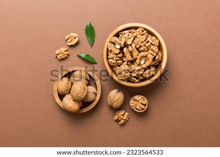 Walnut kernel halves, in a wooden bowl. Close-up, from above on colored background. Healthy eating Walnut concept. Super foods with copy space.