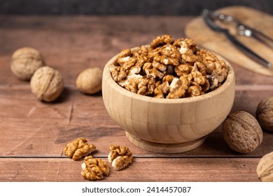 Walnut kernel in a wooden bowl. Shelled, dried seeds of walnuts in wooden bowl. Copy space.