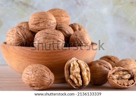 Walnut kernels and whole walnuts on wooden background,front view