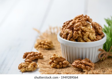 Walnut in white cup on wood background. healthy nuts concept. Walnuts are an excellent source of antioxidants and including LDL cholesterol, which promotes atherosclerosis. - Shutterstock ID 1949289064