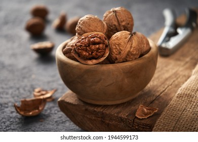 Walnuts in a bowl. The process of splitting nuts. Rustic style.                               