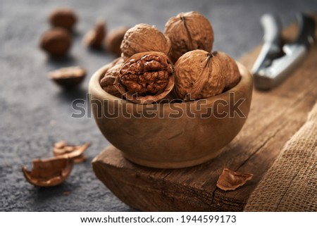 Walnuts in a bowl. The process of splitting nuts. Rustic style.                               