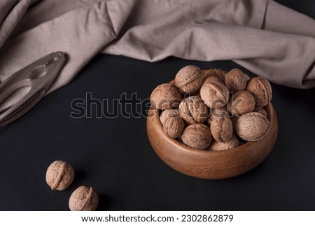 Walnuts are in a cup. Dark background
