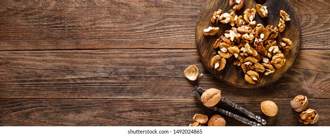 Walnuts. Kernels and whole nuts on wooden rustic table, banner, top view