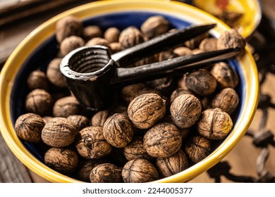 Walnuts and nutcracker in bowl closeup. Deicious nuts for vegetarian heathy diet and protein nutrition