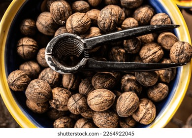 Walnuts and nutcracker in bowl closeup. Deicious nuts for vegan heathy protein diet and nutrition