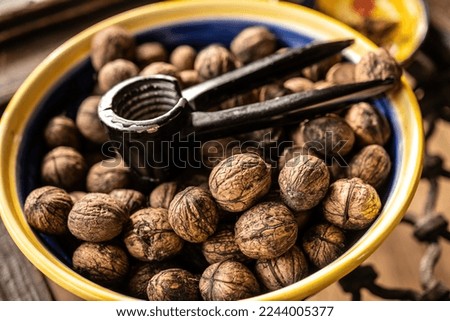 Walnuts and nutcracker in bowl closeup. Deicious nuts for vegetarian heathy diet and protein nutrition