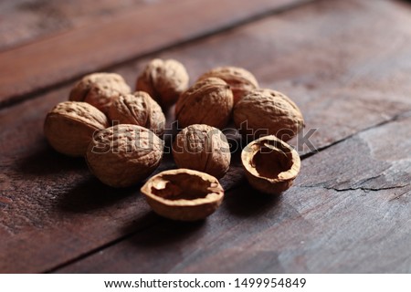 Walnuts and nutshell isolated on the old wooden background in backlight