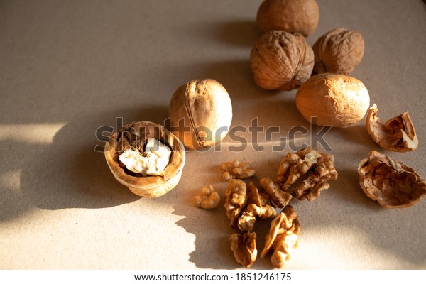 Walnuts on a horizontal surface.\
Several walnuts in the shell and one nut divided into half. Walnut\
kernel in the shape of a heart. Nuts for making nut\
paste.