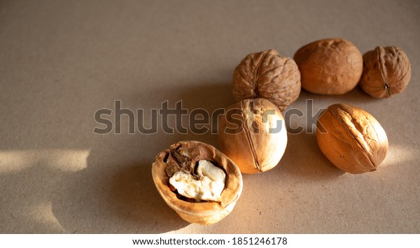 Walnuts on a horizontal surface.\
Several walnuts in the shell and one nut divided into half. Walnut\
kernel in the shape of a heart. Nuts for making nut\
paste.