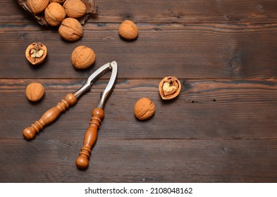 Walnuts In The Shell And A Nutcracker On A Wooden Background,copy Space