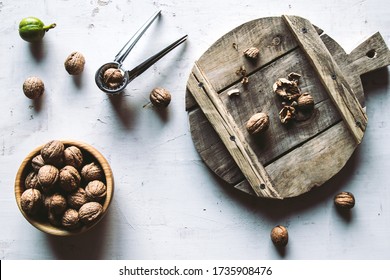 Walnuts in wooden bowl on table with Nutcracker.