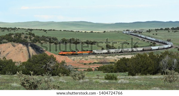 Walsenburg, CO, USA. May 5, 2019. Very long BNSF train\
sitting idle on the train tracks outside Walsenburg, Co, waiting\
for the all clear signal so they can then continue on to their\
destination.  