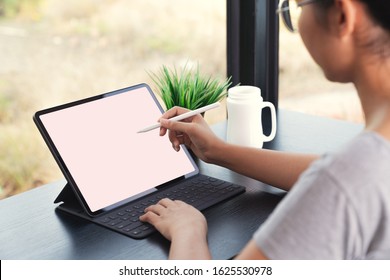 waman using digital tablet with stylus pen and smart keyboard