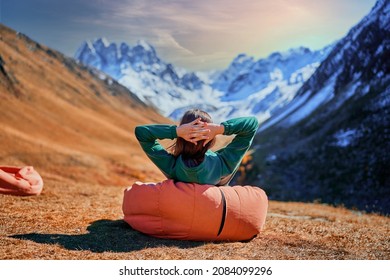 Wanderer girl sitting on soft chair during resting in a camping. Traveler enjoying scenic landscape while traveling in a mountain valley - Shutterstock ID 2084099296
