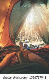 wanderlust - man relaxing in tent after hike with cup of tea