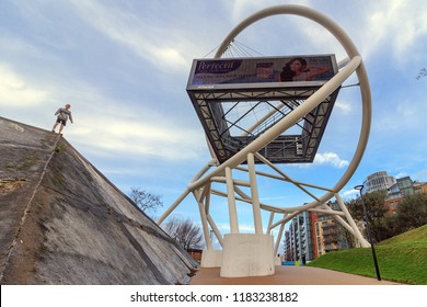 WANDSWORTH, LONDON - January 2, 2018: Young Man Is Standing On Small Architectural Forms On The Street. Sport Parkour. Wandsworth Roundabout Sculpture. Billboard, Hoarding Is Large Outdoor Advertising