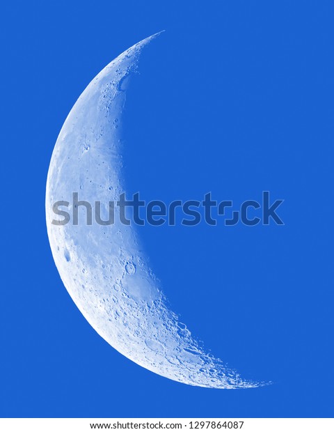 Waning Crescent Moon on blue\
sky.