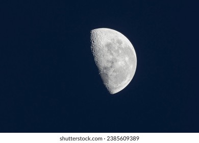 A waning moon in the dark sky. Astronomy.