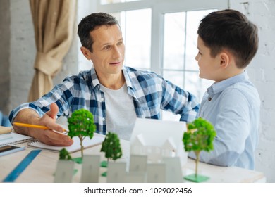 Want To Know More. Pleasant Pre-teen Boy Asking His Father About His Work As An Architect, Being Interested In His Recent Project Of Eco-city, While The Man Telling Eagerly