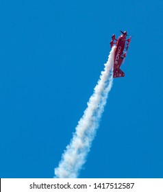 Wantagh, New York, USA - 24 May 2019: The Oracle d bi-plane perfoming on the Friday practice day of Memorial Day weekend at Jones Beach, NY. climbing high into the sky leaving a trail of smoke.