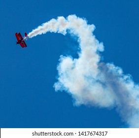 Wantagh, New York, USA - 24 May 2019: The Oracle d bi-plane perfoming on the Friday practice day of Memorial Day weekend at Jones Beach, NY, twisting in sky leavig a trail of smoke.