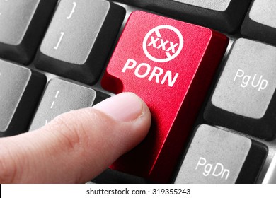 Wanting to watch porn. gesture of finger pressing porn button on a computer keyboard