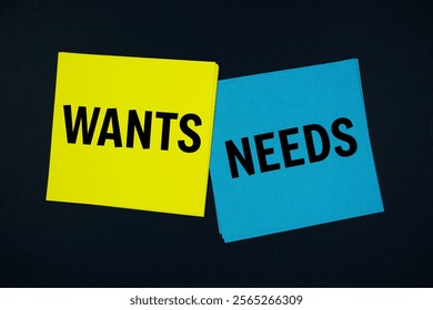 Wants vs Needs text message on stick note on black background