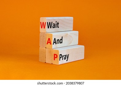 WAP, Wait and pray symbol. Wooden blocks with concept words 'WAP, Wait and pray'. Beautiful orange background, copy space. Religion and WAP, wait and pray concept.