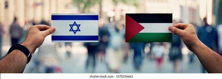 War Between Palestine And Israel As Two Hands Holding Flags. Dispute On Politics, Culture, Religion And Territory. Diplomacy And Future Strategic Relations. Opposite Conflict Concept And Bombings