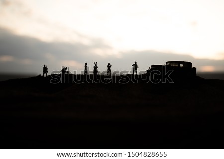 War concept. Creative composition. Silhouette of German general at the desert. Army commanders watching to the battle. Military fighting silhouettes on sunset