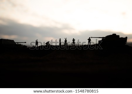 War concept. Creative composition. Silhouette of German general at the desert. Army commanders watching to the battle. Military fighting silhouettes on sunset