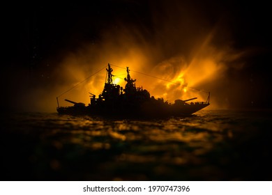 War concept. Night battle scene at sea. Dramatic toned clouds effect. Silhouette of the battle ship in night. Miniature creative table decoration. Selective focus