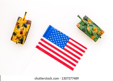 War, Military Threat, Military Power Concept. USA. Tanks Toy Near American Flag On White Background Top View