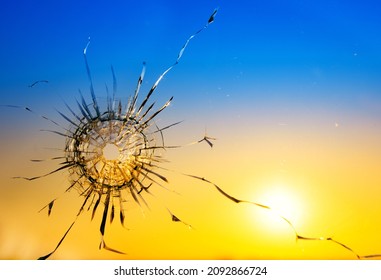 War threat concept. Hole in the glass from a bullet on the background of the flag of Ukraine - Shutterstock ID 2092866724
