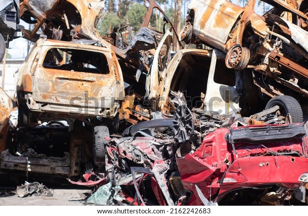 war in ukraine. Car\
graveyard. Shot cars of civilians. russia\'s war against Ukraine.\
Burnt and blown up car. Cars damaged after shelling. irpin bucha.\
war crimes.
