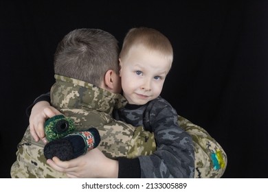 War In Ukraine. Military And Children. Ukrainian Soldier Hugs A Child. Army Protects Country Population From Invaders. Terrorist Activities In The Country. Camouflage Uniform Of Ukrainian Military