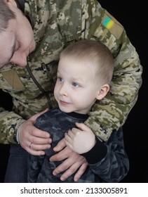 War In Ukraine. Military And Children. Ukrainian Soldier Hugs A Child. Army Protects Country Population From Invaders. Terrorist Activities In The Country. Camouflage Uniform Of Ukrainian Military