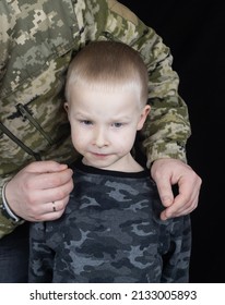 War In Ukraine. Military And Children. Ukrainian Soldier Hugs A Child. Army Protects Country Population From Invaders. Terrorist Activities In The Country. Camouflage Uniform Of Ukrainian Military