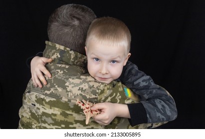 War In Ukraine. Military And Children. Ukrainian Soldier Hugs A Child. Army Protects Country Population From Invaders. Terrorist Activities In The Country. Camouflage Uniform Of Ukrainian Military