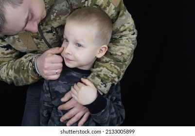 War In Ukraine. Military And Children. Ukrainian Soldier Hugs A Child. Army Protects Country Population From Invaders. Terrorist Activities In The Country. Camouflage Uniform Of Ukrainian Military