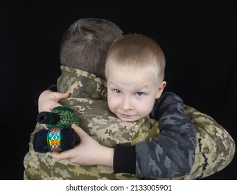 War In Ukraine. Military And Children. Ukrainian Soldier Hugs A Child. Army Protects Country Population From Invaders. Terrorist Activities In The Country. Camouflage Uniform Of Ukrainian Military