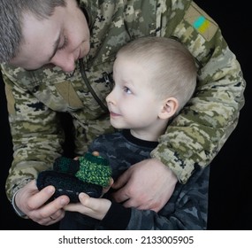 War In Ukraine. Military And Children. Ukrainian Soldier Hugs A Child. Army Protects Country Population From Invaders. Terrorist Activities In The Country. Camouflage Uniform Of Ukrainian Military