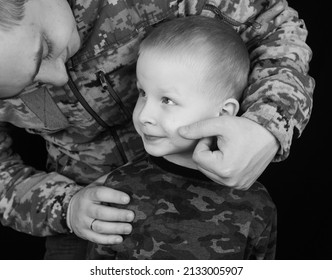 War In Ukraine. Military And Children. Ukrainian Soldier Hugs A Child. Army Protects Country Population From Invaders. Terrorist Activities In The Country. Camouflage Uniform Of Ukrainian Military