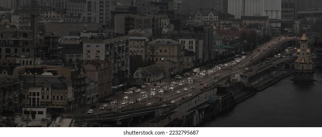 War in Ukraine.  View of Kyiv from the observation deck in the evening during a blackout. Dark houses and unlit streets are visible, and the lights of passing cars are visible. - Shutterstock ID 2232795687