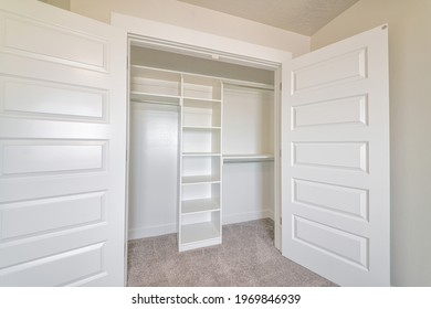 Wardrobe Cabinet With Empty Clothes Rod And Shelves Inside A Residential Home. Storage Organization Ideas With Close Up View Of A Small Closet With Double Doors.