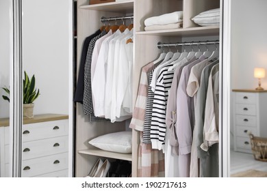 Wardrobe closet with different stylish clothes in room, closeup - Shutterstock ID 1902717613