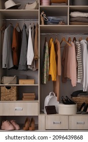 Wardrobe closet with different stylish clothes, accessories and shoes
