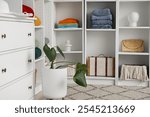 Wardrobe with clothes and chest of drawers in dressing room